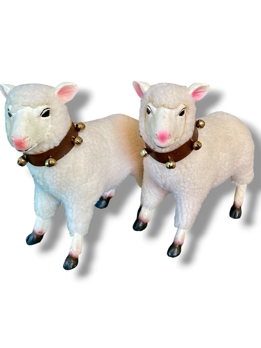Two resin sheep with fleece covered bodies, leather collars, and bells